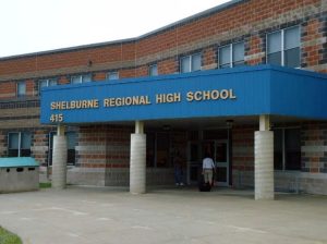A two-story brick building with a sign that reads "Shelburne Regional High School".